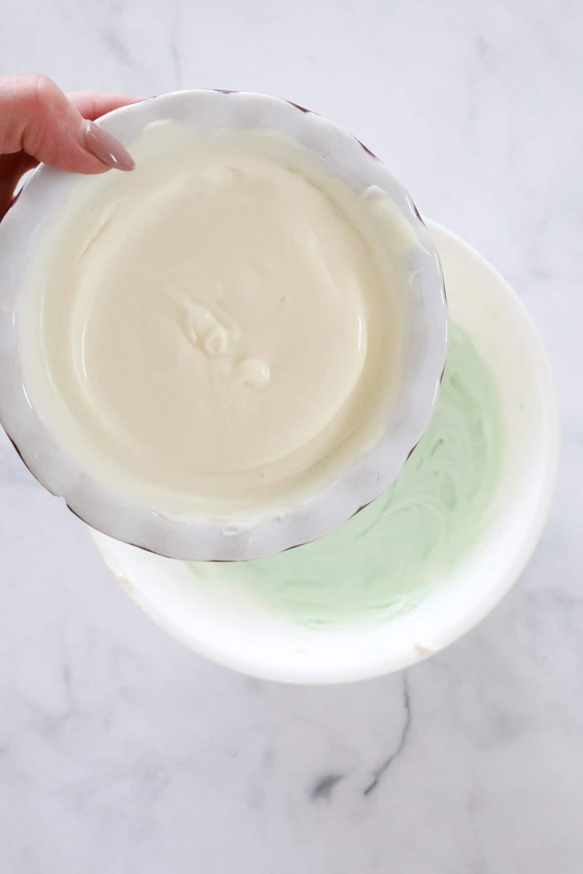 The gelatine white chocolate mixture being poured into the cream cheese mixture.