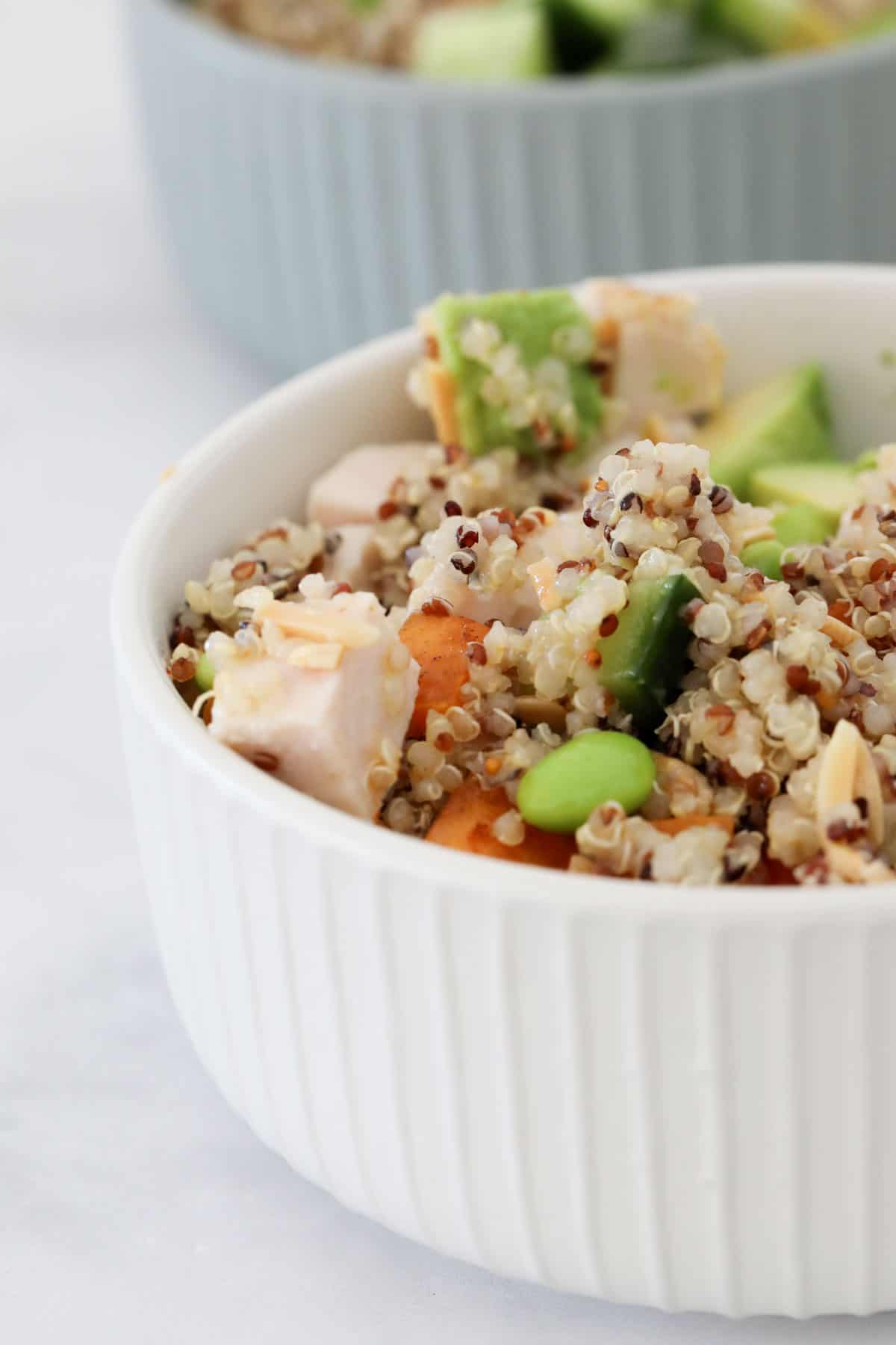 Quinoa mixed with all other ingredients and served in a white bowl.