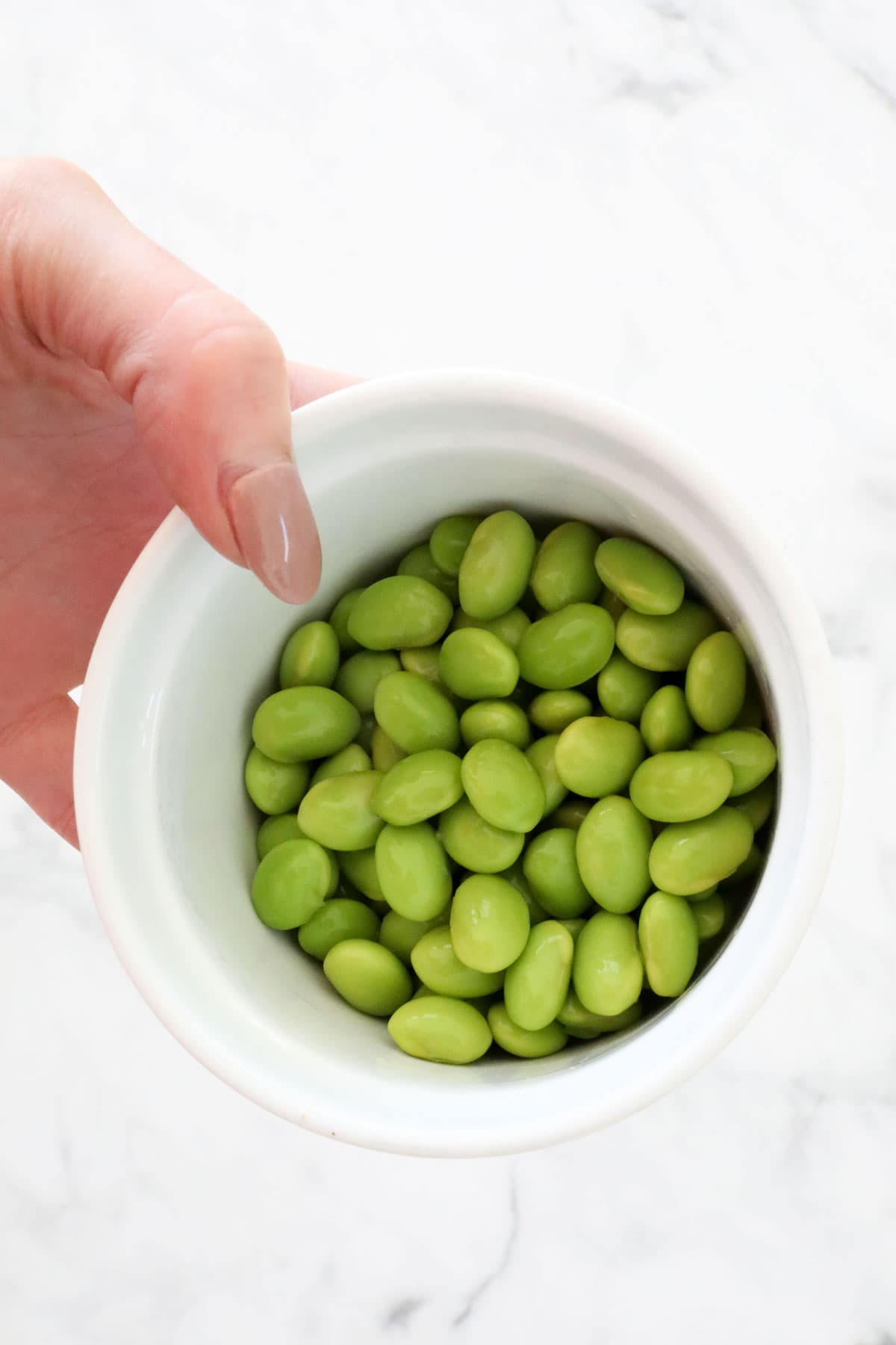 A small bowl of cooked endamame beans.