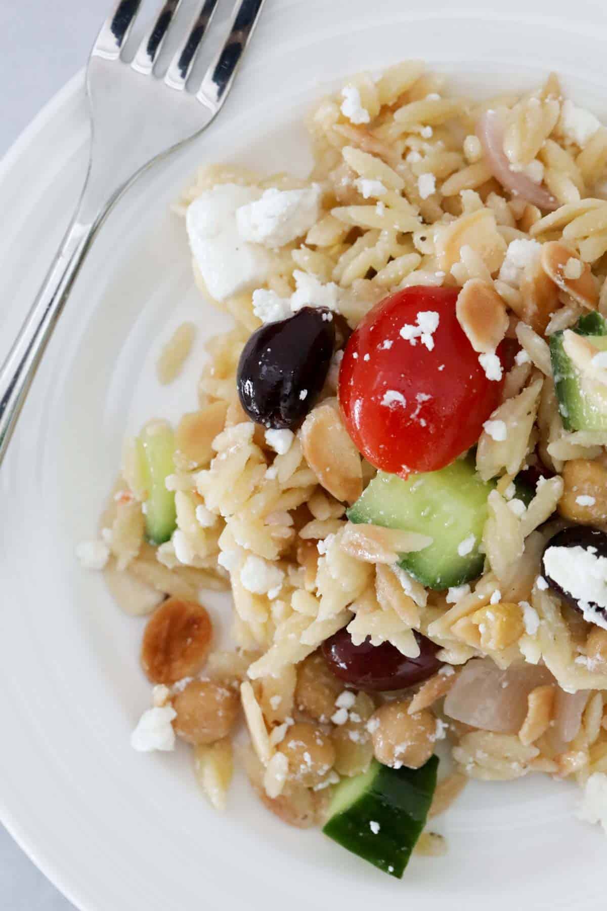 Orzo salad served on a white plate.