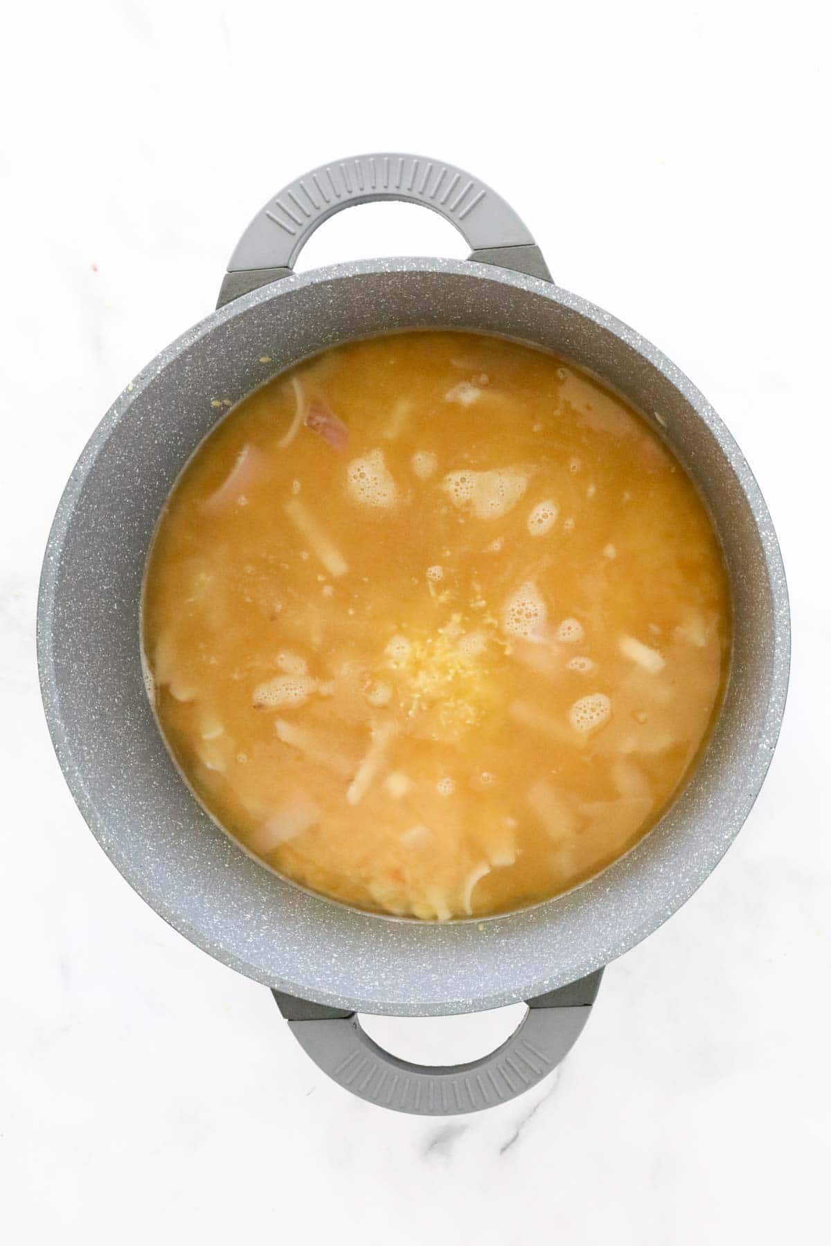 Chicken stock poured into the saucepan.