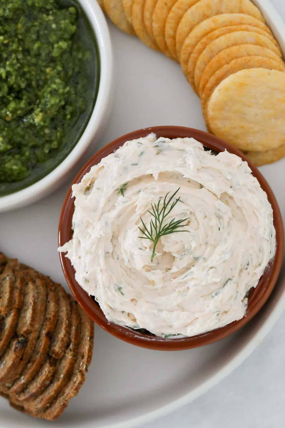 A bowl of smoked salmon dip served with crackers.