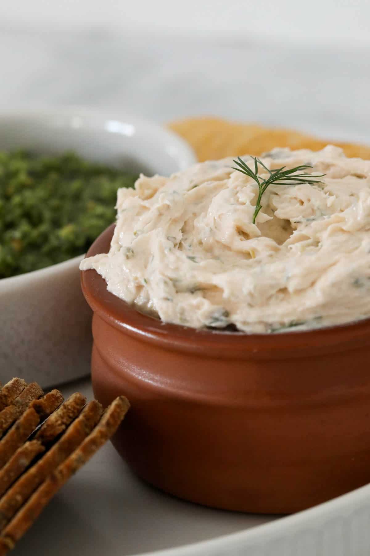 A bowl of smoked salmon dip served with crackers.