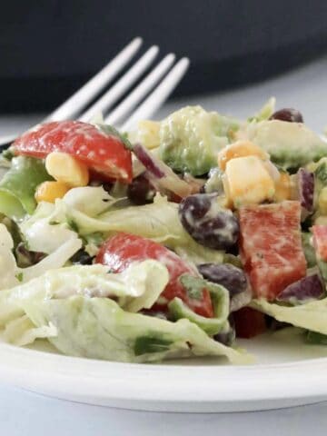 A plate of a Mexican style salad with a creamy avocado dressing.