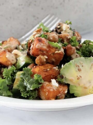 A plate of creamy kale, sweet potato, avocado and chickpea salad.