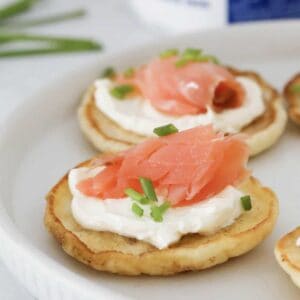 A four ingredient blini topped with cream cheese, smoked salmon and chives.