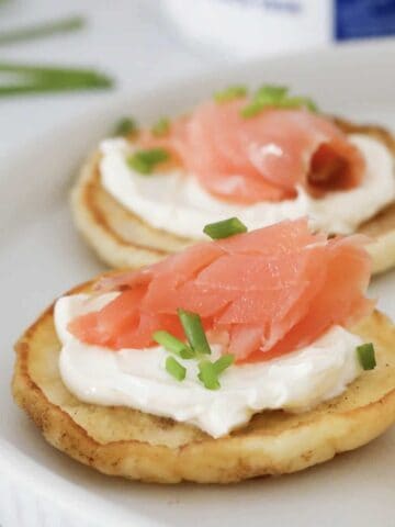 A four ingredient blini topped with cream cheese, smoked salmon and chives.