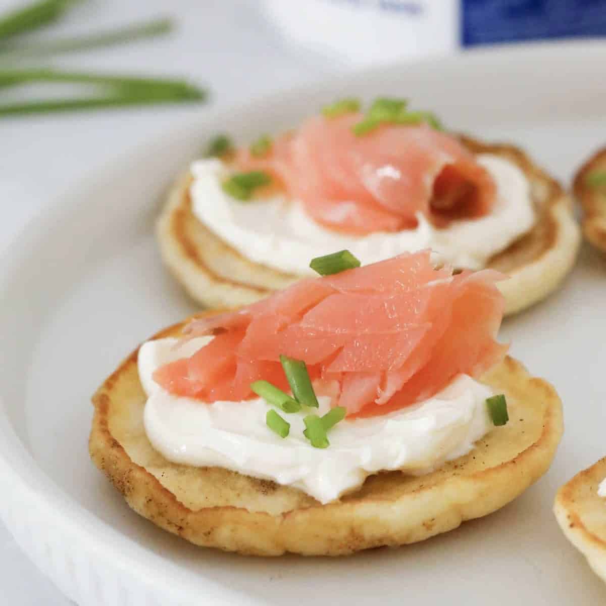 A four ingredient blini topped with cream cheese, smoked salmon and chives.