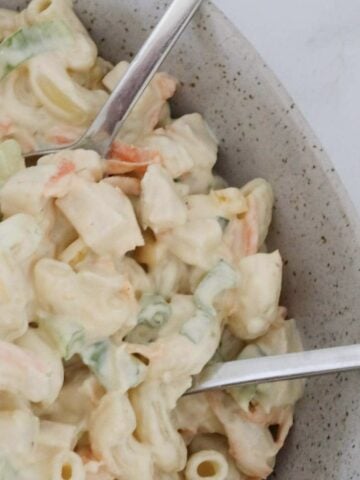 A bowl of creamy pasta salad with chunks of chicken.