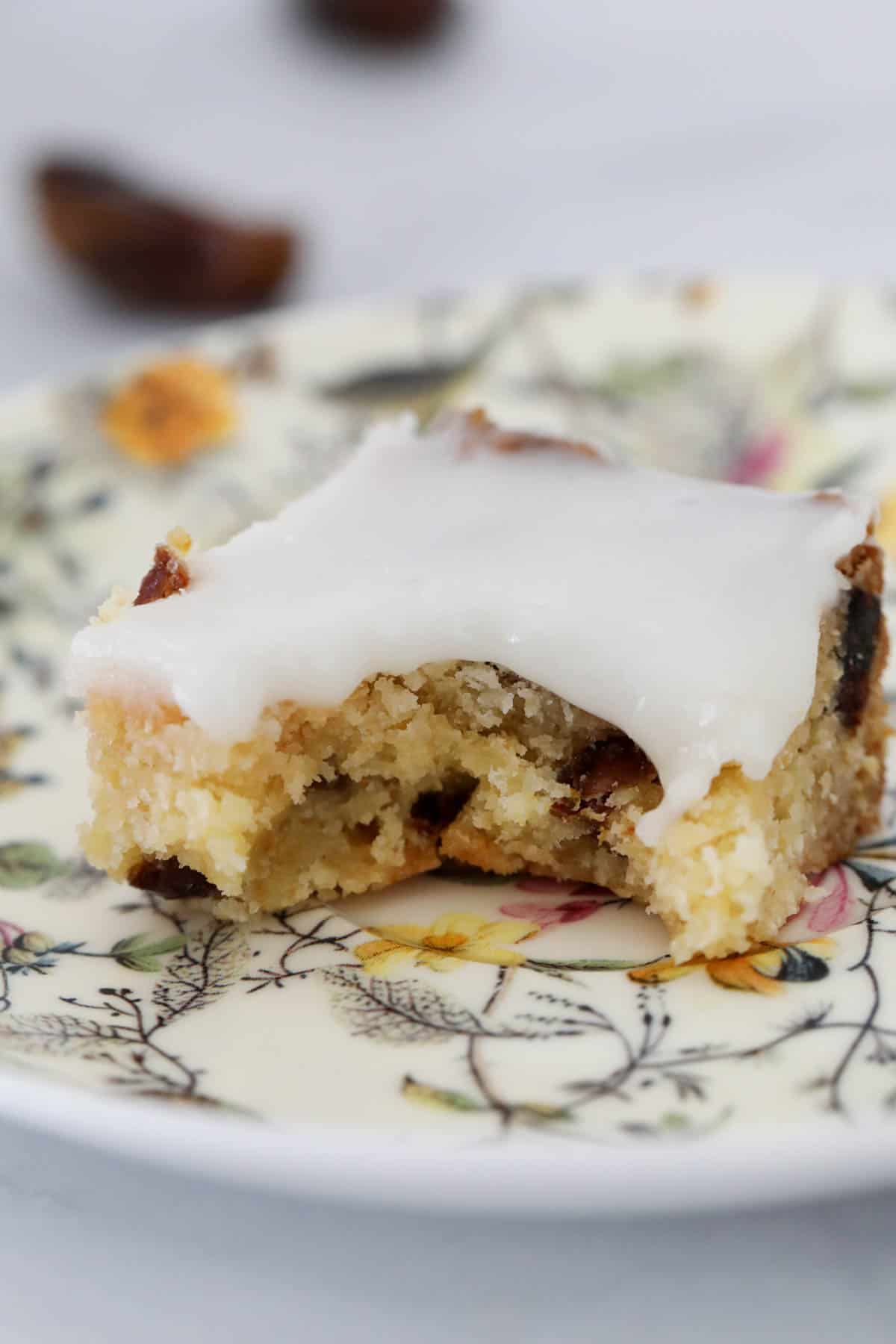 A square of an iced slice with a bite taken out.