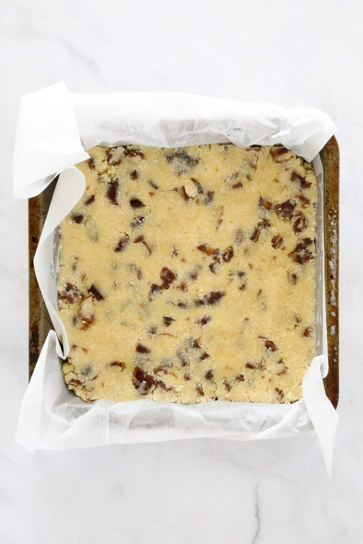 Slice mixture pressed into a square baking tin, ready to go in the oven.