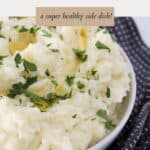 A dish filled with creamy mashed potato and cauliflower, sprinkled with parsley.