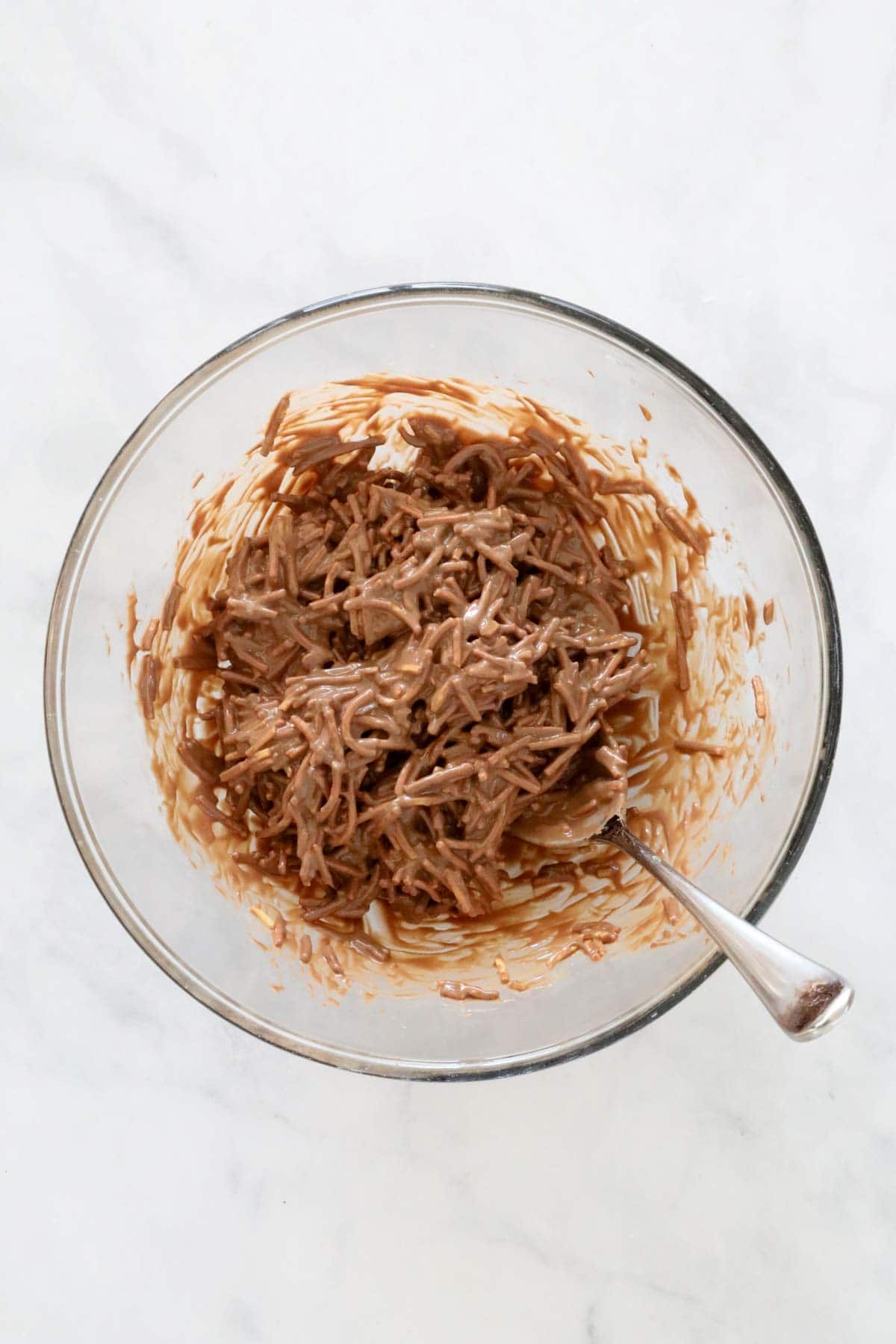 Fried noodles stirred through the mixture in a bowl.