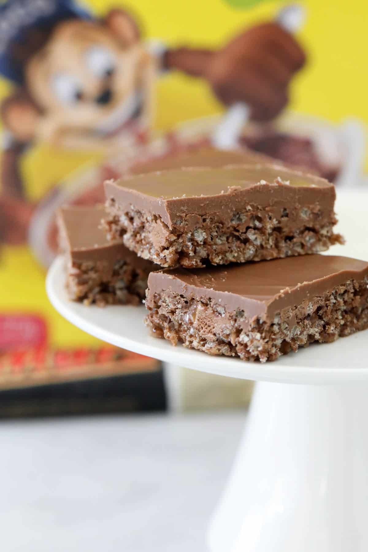 Pieces of crunchy chocolate Coco Pop slice with a box of Coco Pops in the background.