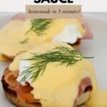 Creamy hollandaise sauce drizzled over eggs and bacon on a toasted muffin, with a sprig of dill to garnish.