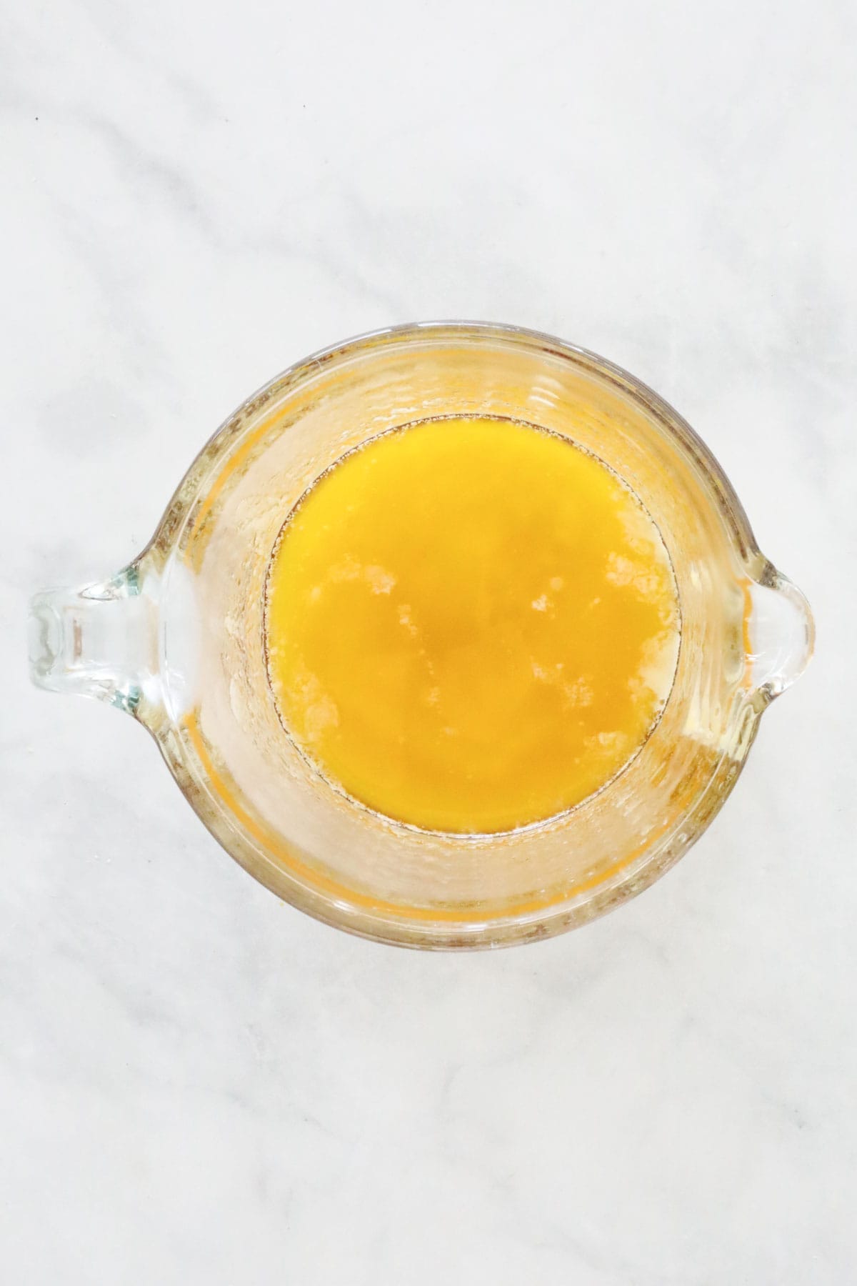 Melted butter and golden sugar in a glass jug.