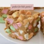 Close up of a square of peanut butter slice filled with colourful mini marshmallows.