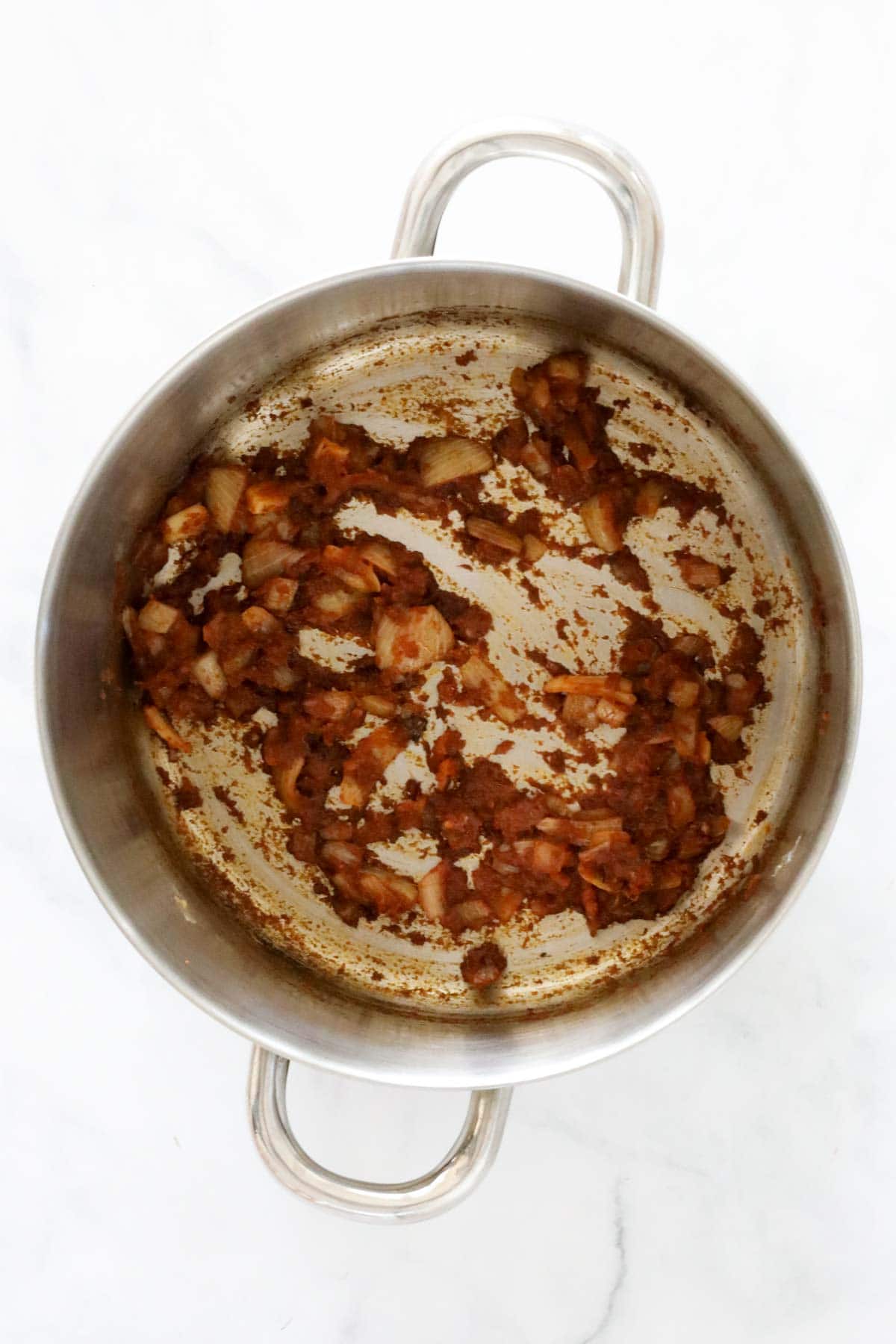 Garlic, ginger and red curry paste added to the saucepan.