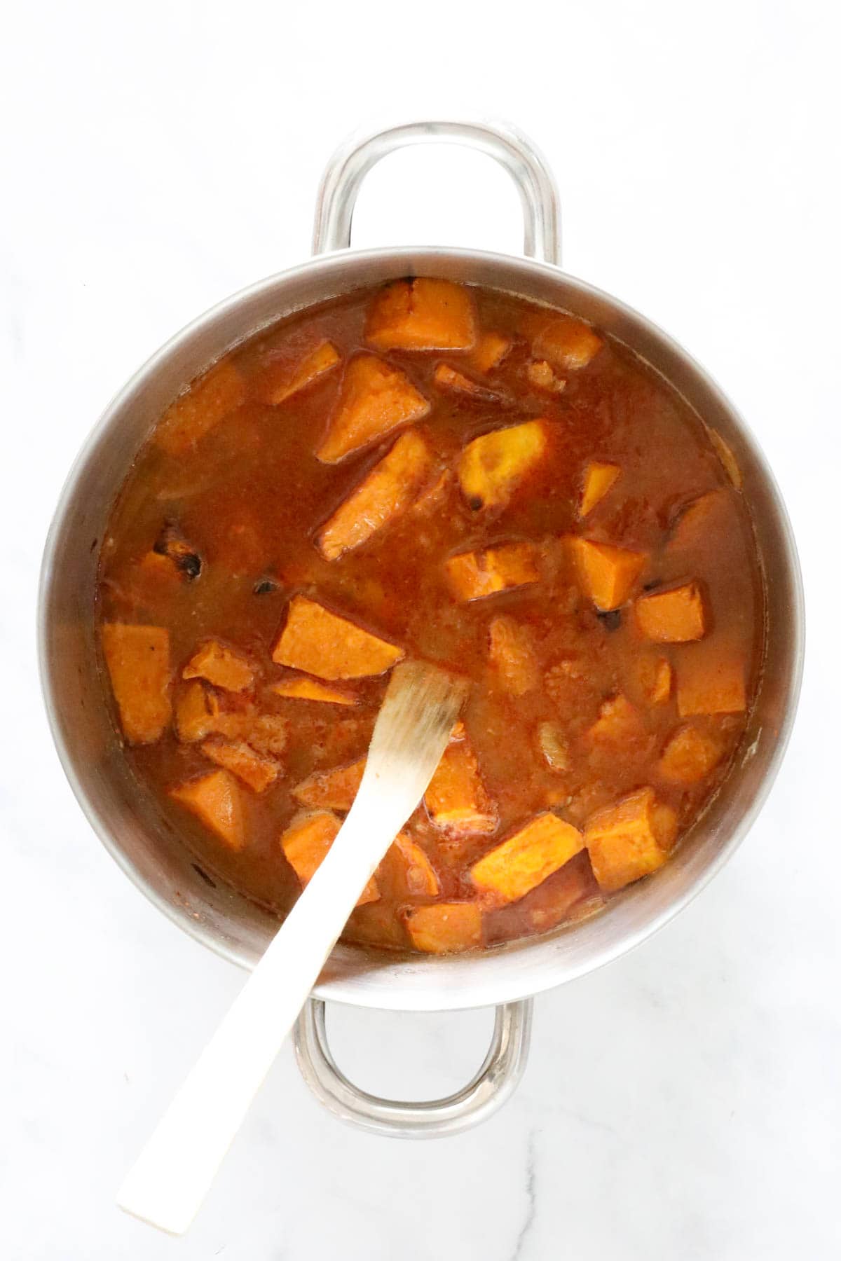 Saucepan full of cooked pumpkin, stock and spicy flavourings.