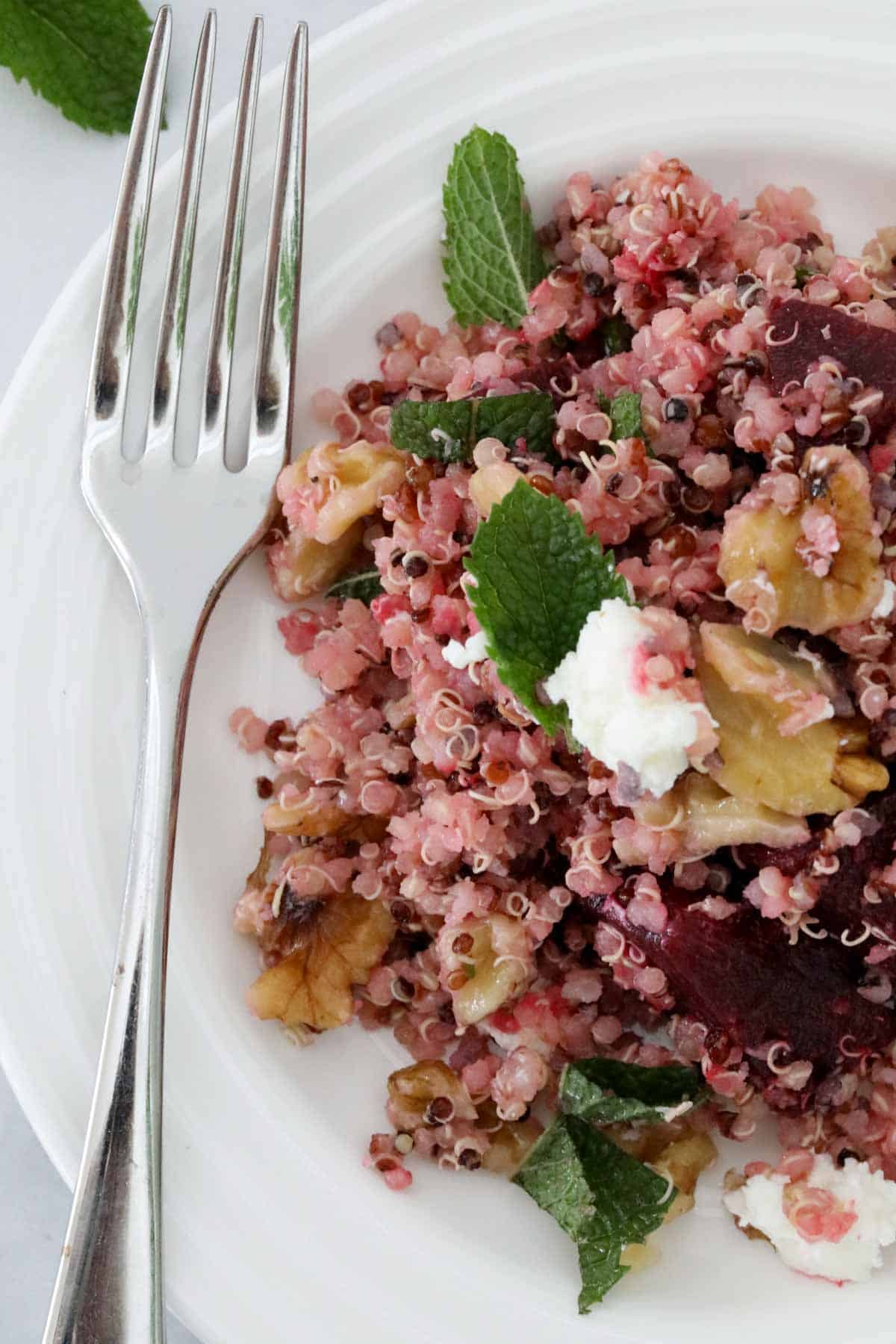 Beetroot and quinoa salad on a plate with a fork beside.