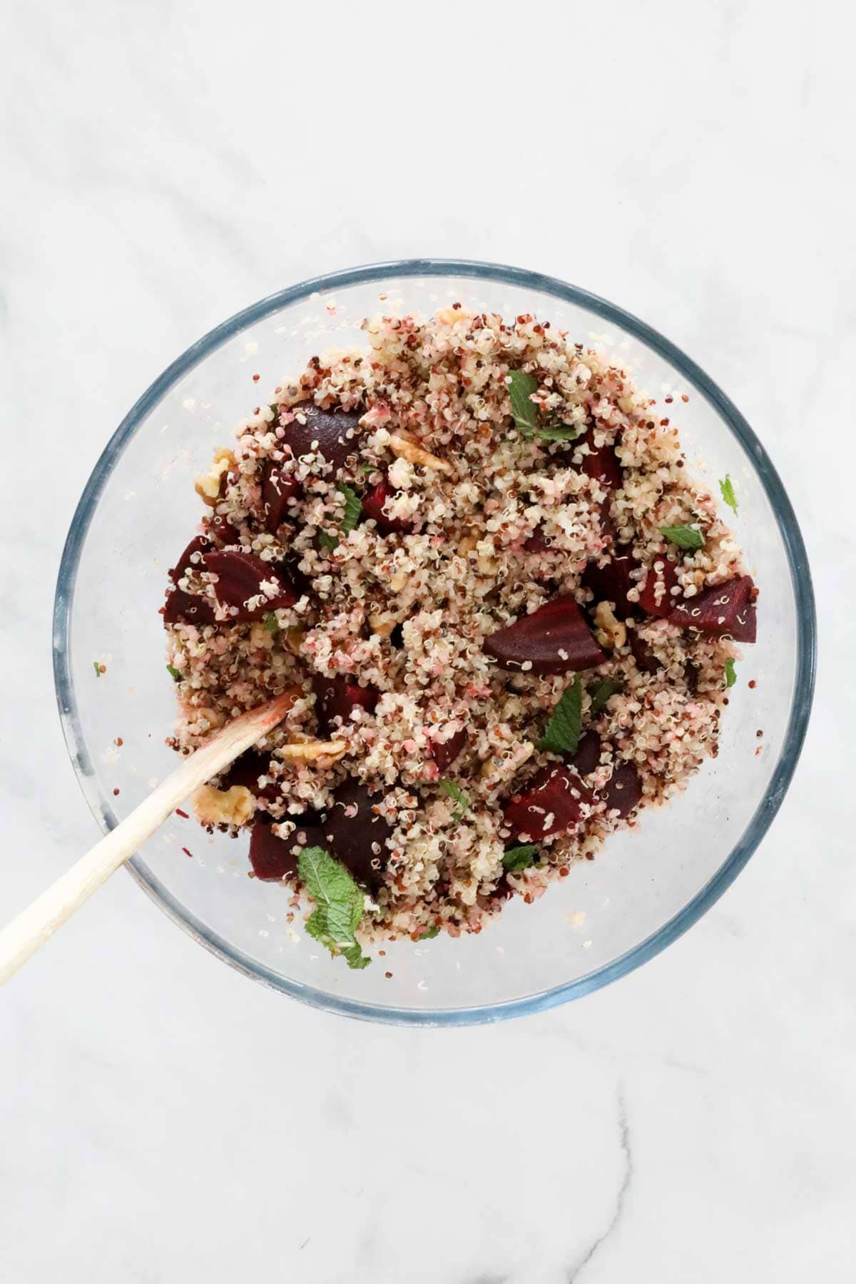 Salad ingredients mixed in a glass bowl.