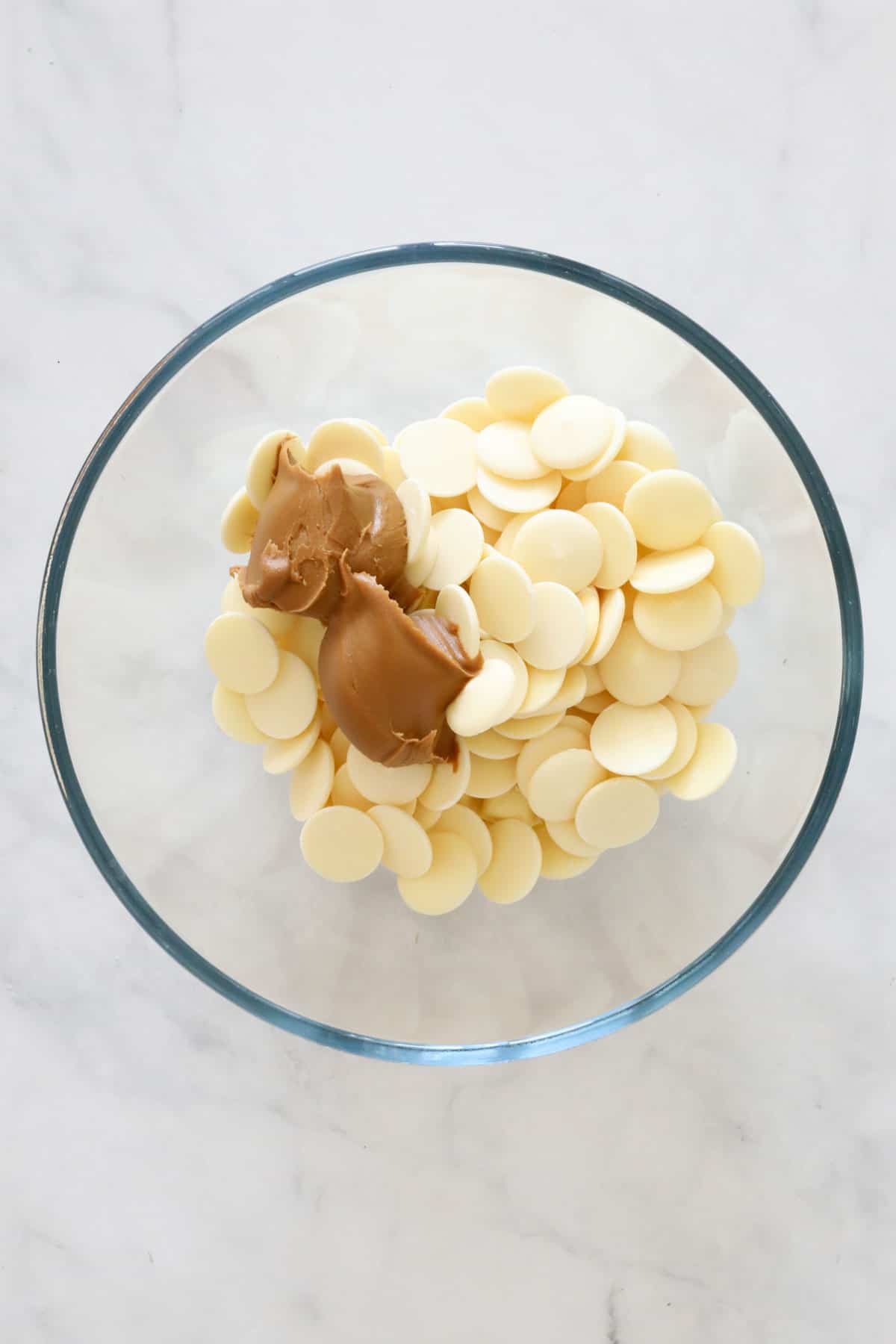 White chocolate melts and Biscoff spread in a glass bowl.