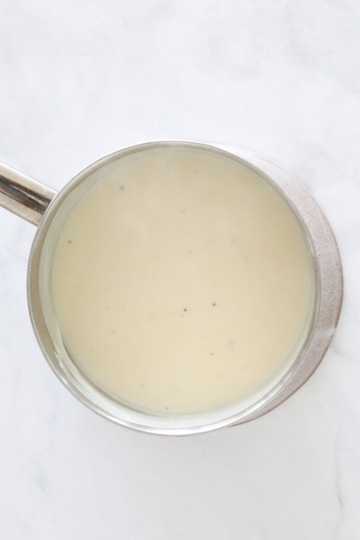 Creamy mornay sauce in a saucepan.