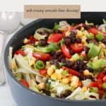 A bowl of Mexican inspired salad with chopped lettuce, black beans, charred corn, capsicum, and spring onions.