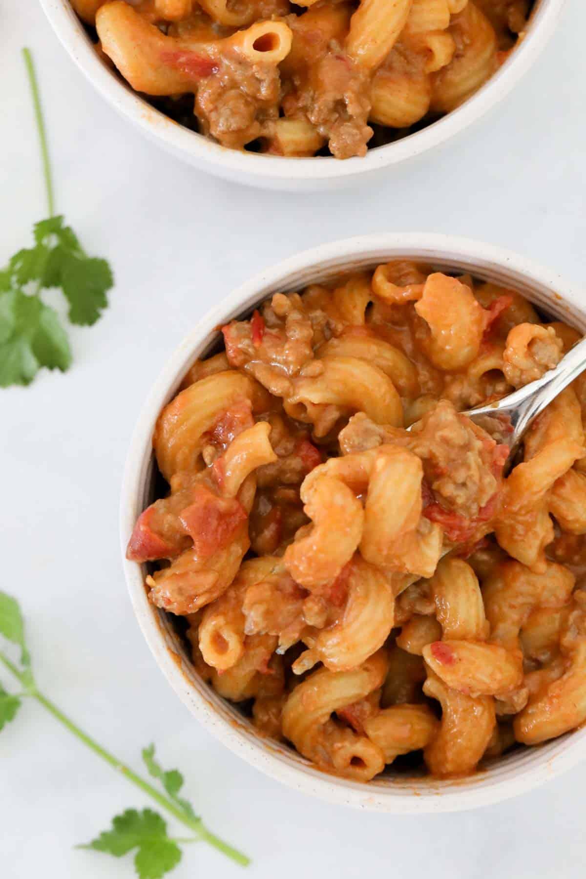 A bowl of beef and tomato taco pasta in a round bowl.