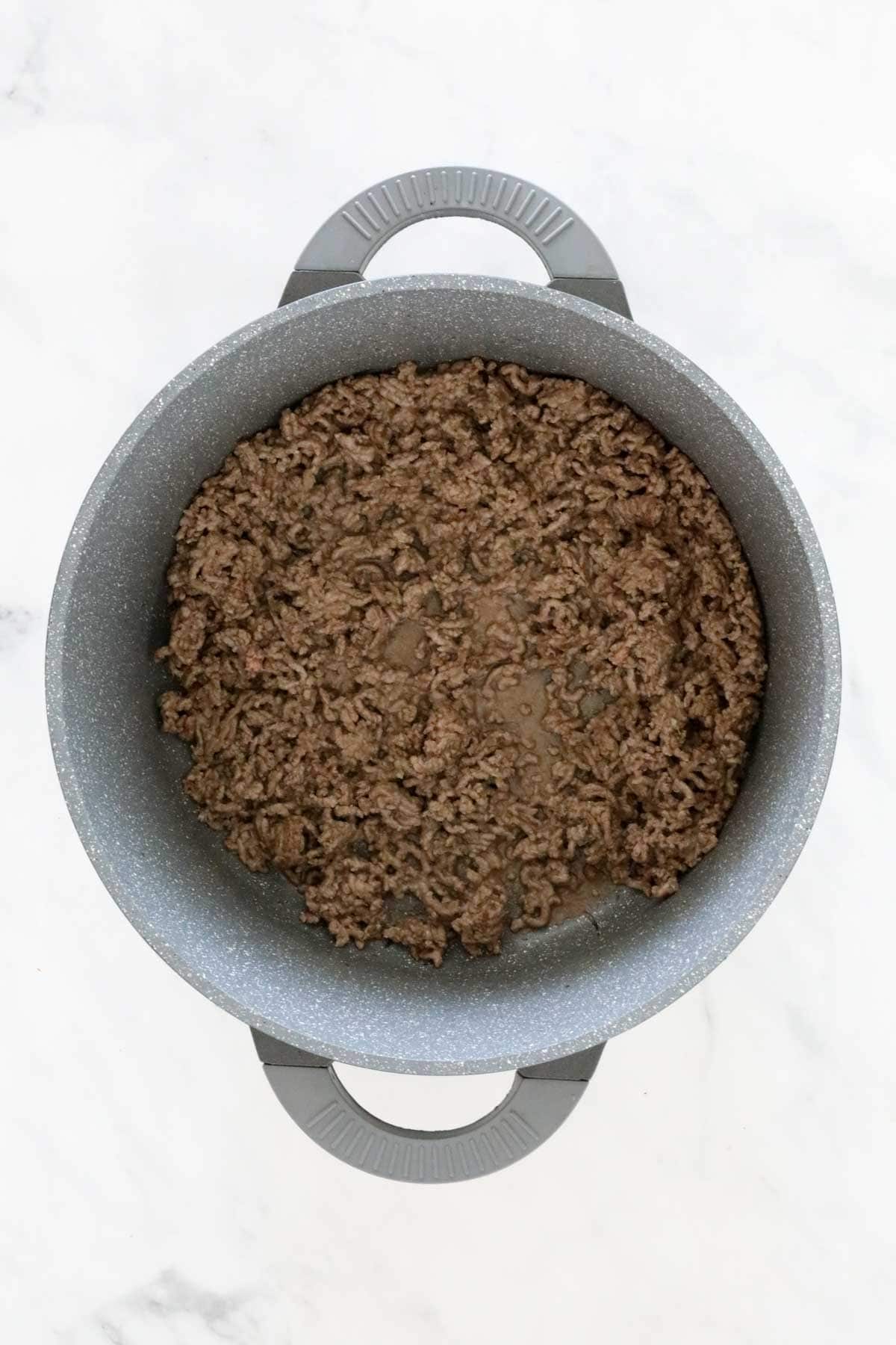 Beef mince browning in a large pan.