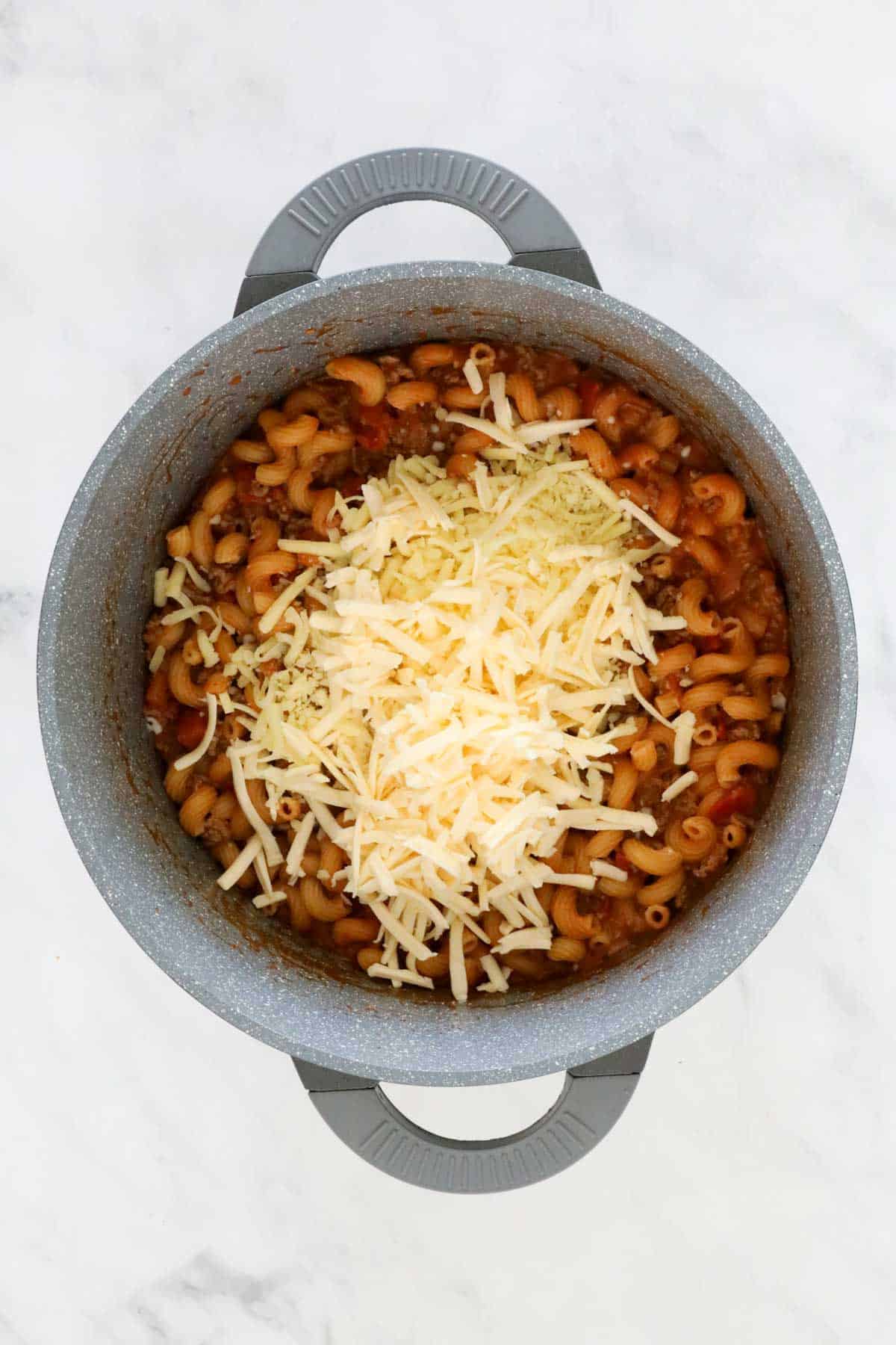 Cheese added to the pan of meat and pasta.
