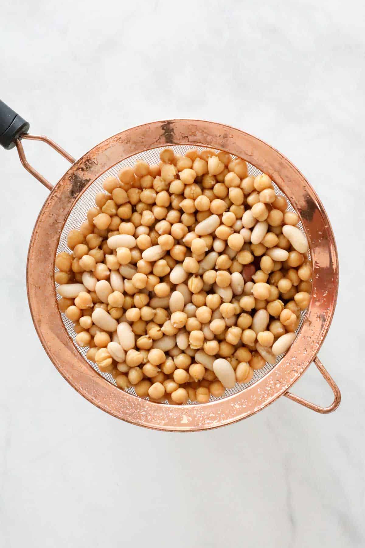 Chickpeas drained in a copped sieve.