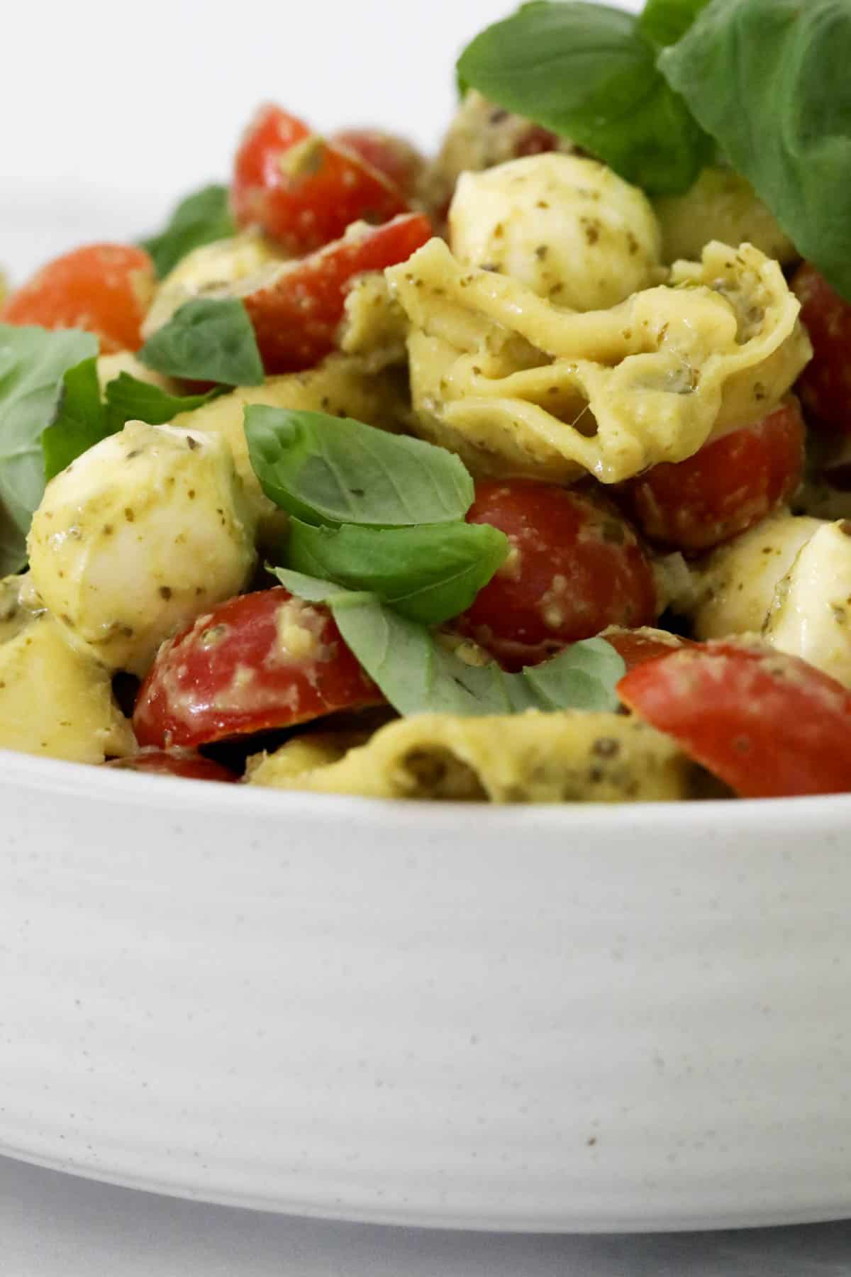 A white bowl filled with an Italian style pesto salad.