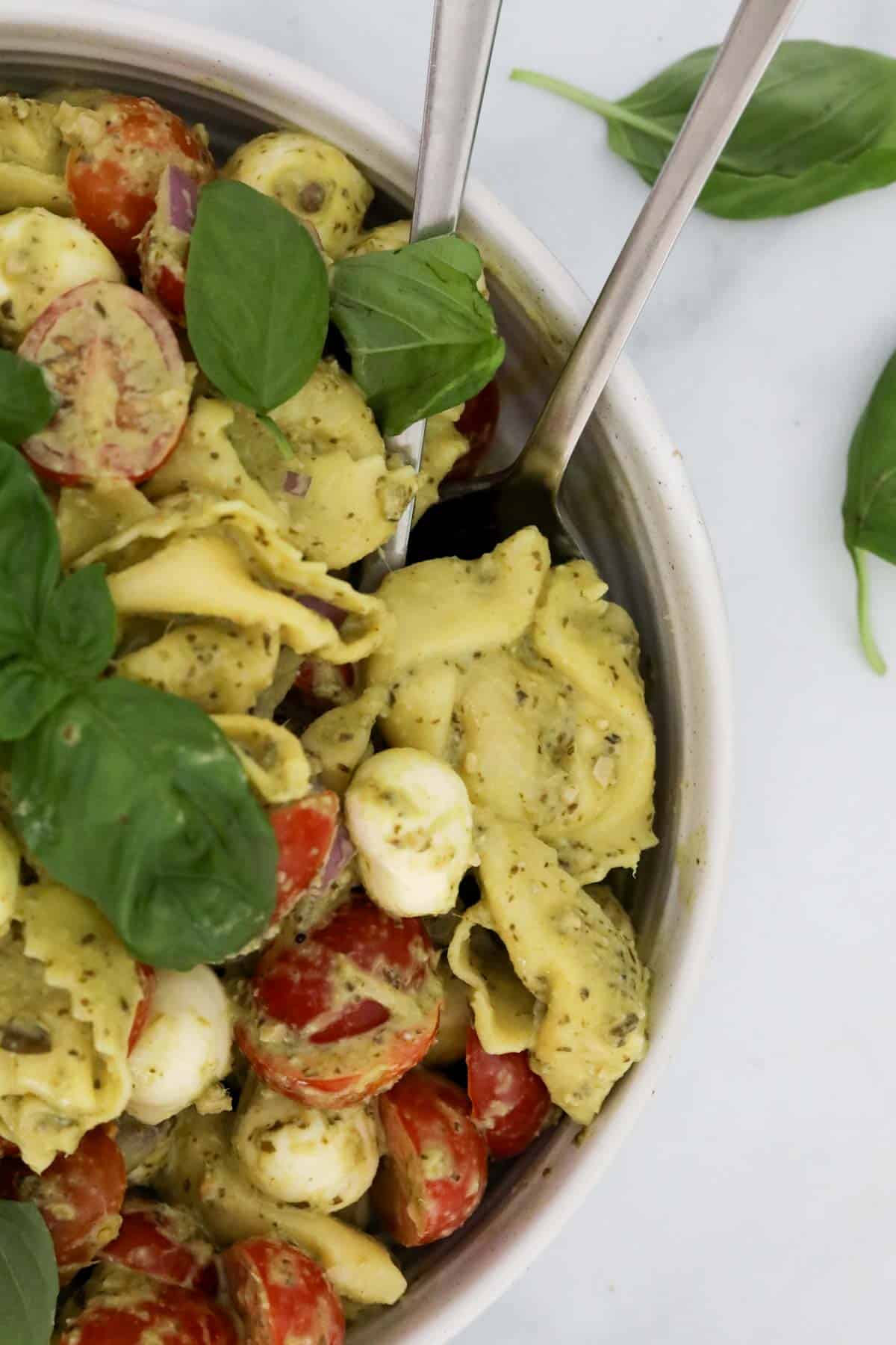 A serving spoon in a bowl of colourful salad.