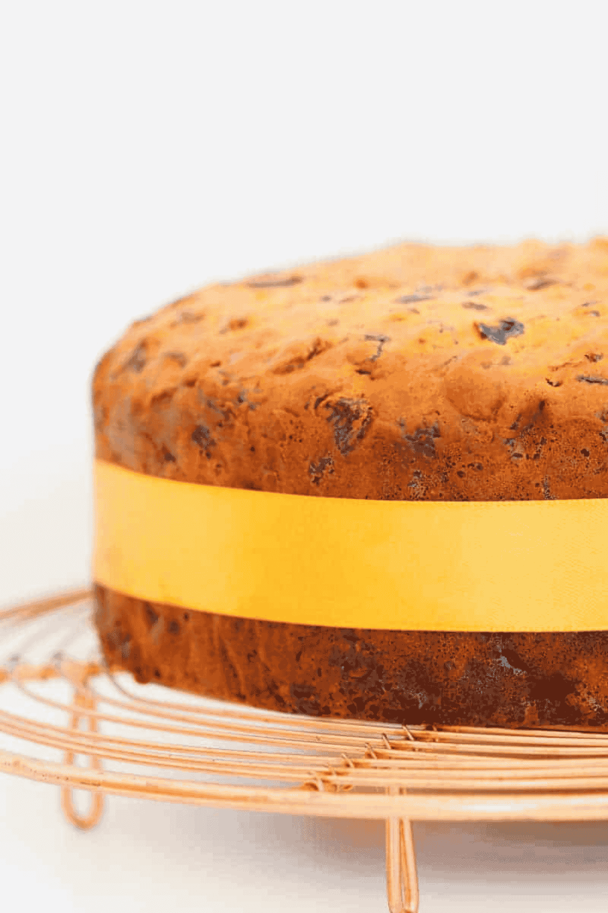 A fruit cake with a yellow ribbon tied around it.