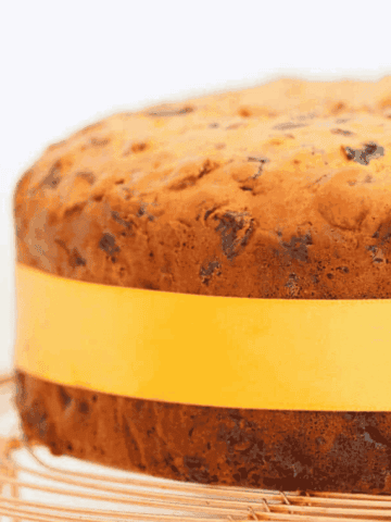 A fruit cake with a yellow ribbon tied around it.