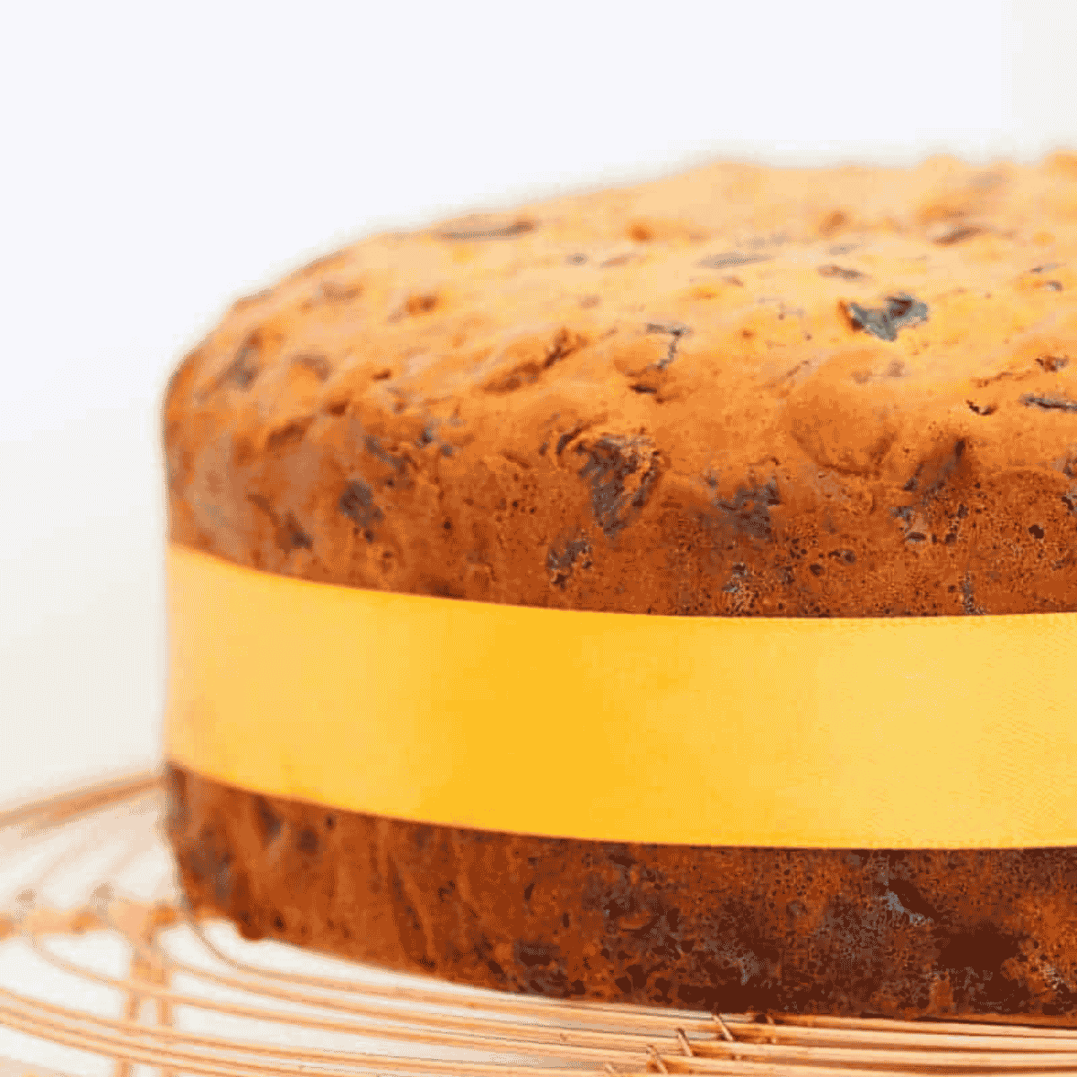 A fruit cake with a yellow ribbon tied around it.