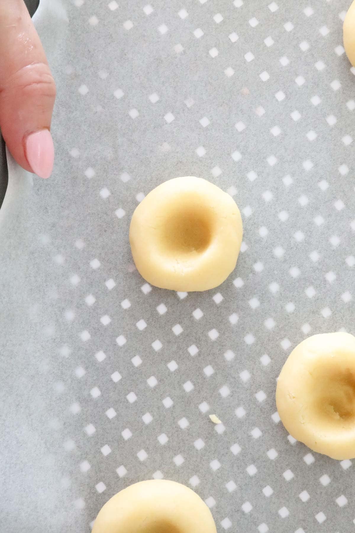 Dough balls showing a deep indent made in the middle of them.