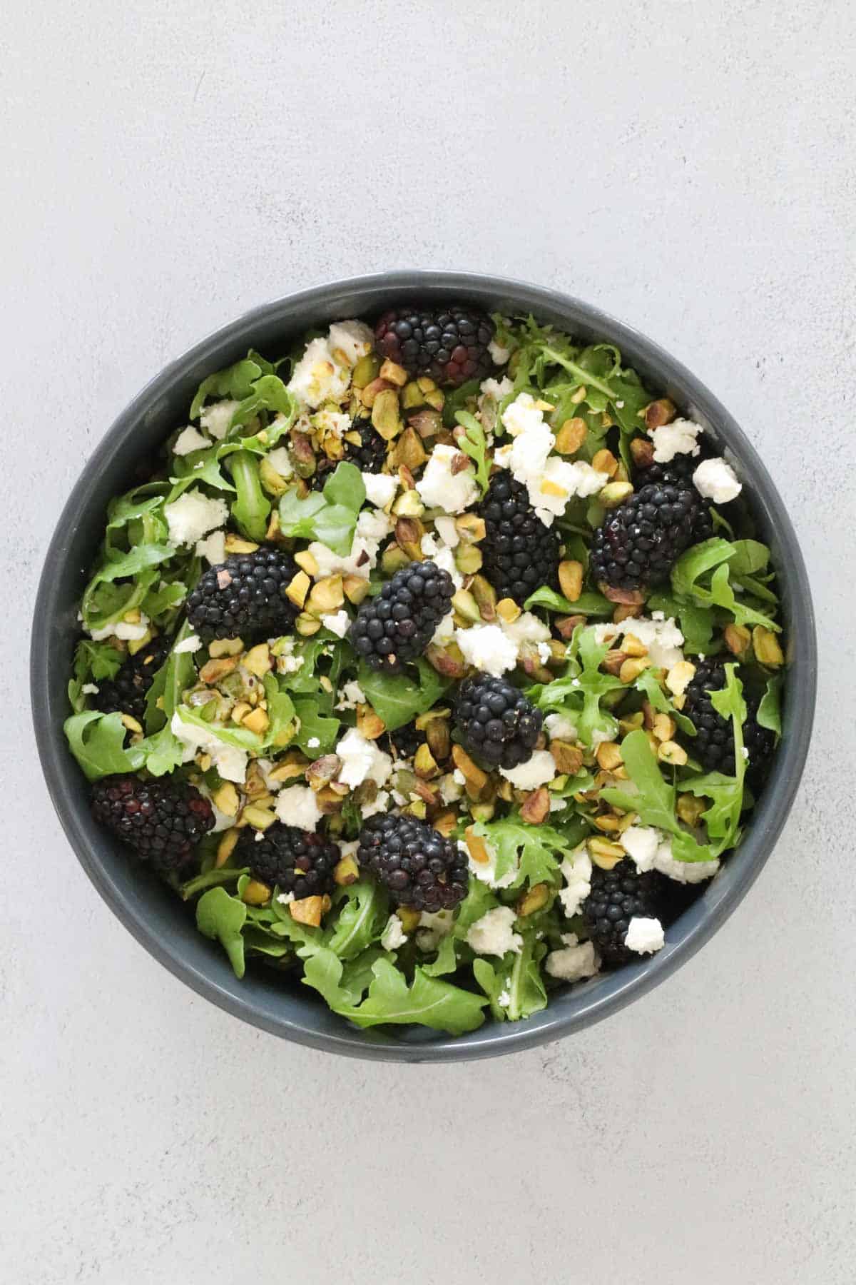 An overhead shot of all salad ingredients in a black bowl.