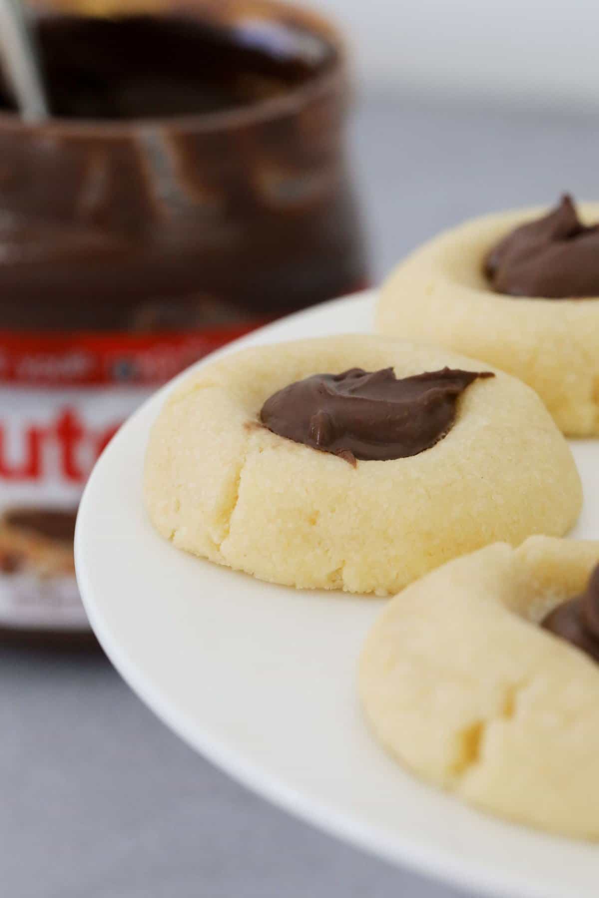 Thumbprint cookies in front of a jar of Nutella.