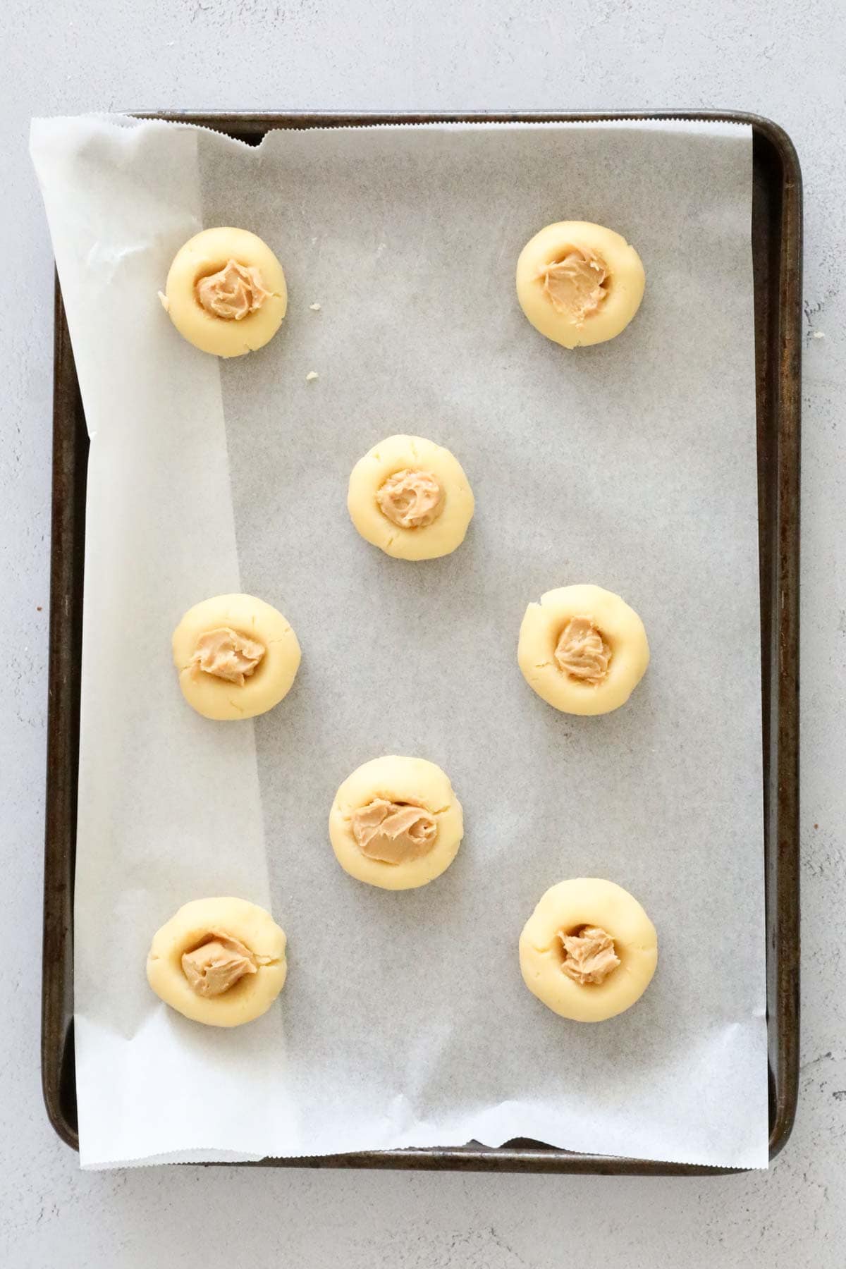 Peanut butter spooned into indents in thumbprint cookies.