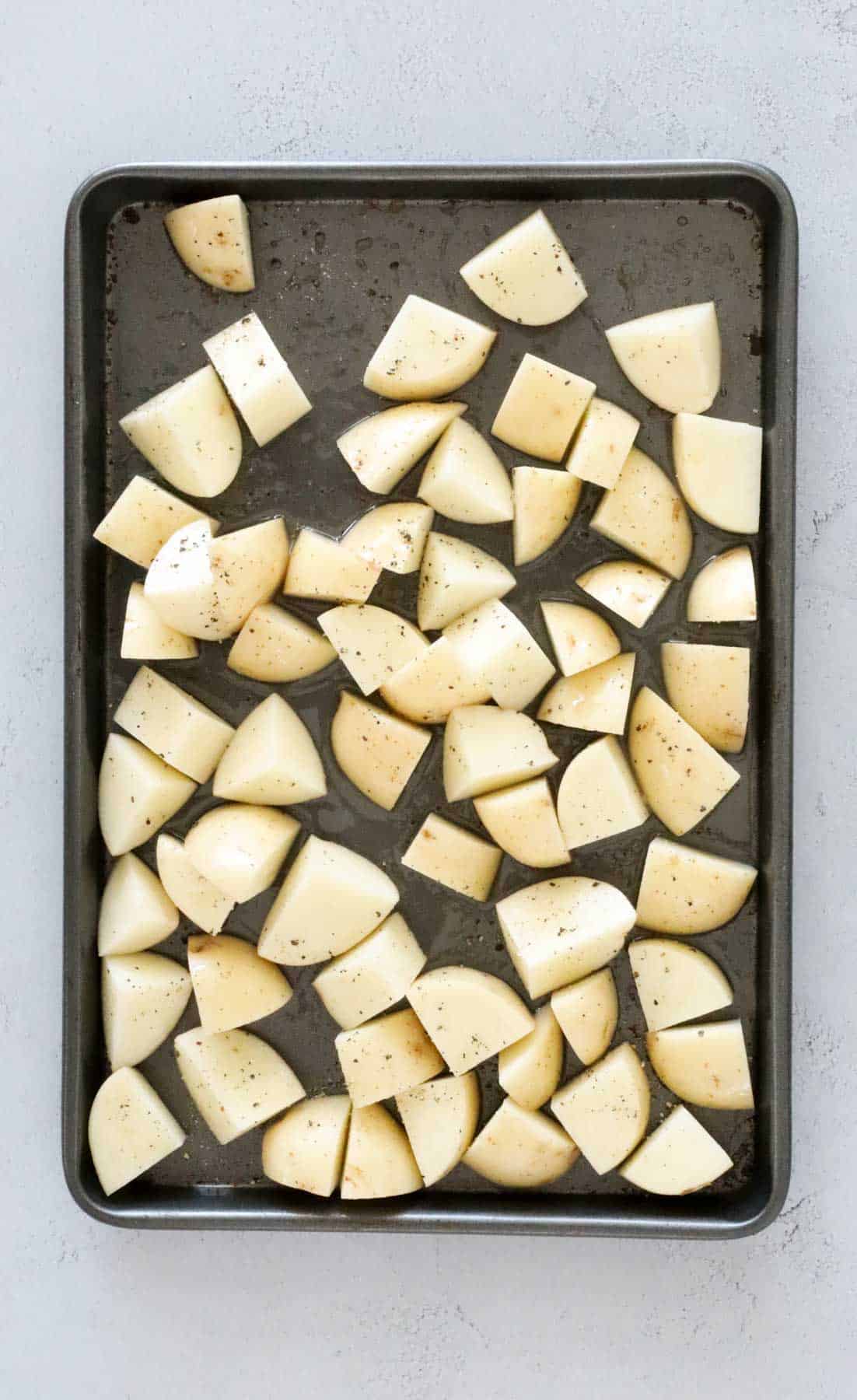 Potato chunks on a baking tray.