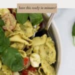 A bowl of pasta salad with tortellini, sprinkled with fresh basil leaves.