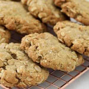 ANZAC oat biscuits cooling on a wire rack.