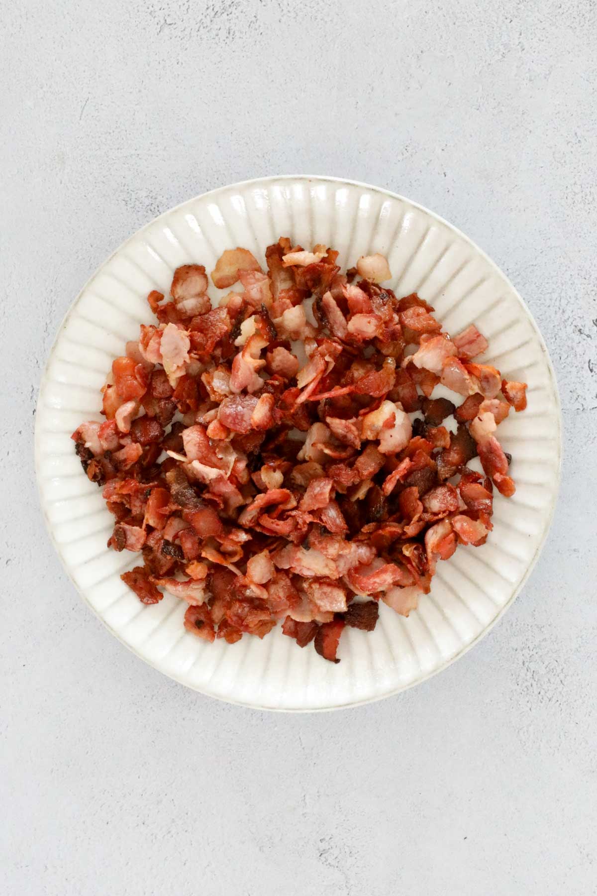 A bowl of crispy fried bacon pieces.