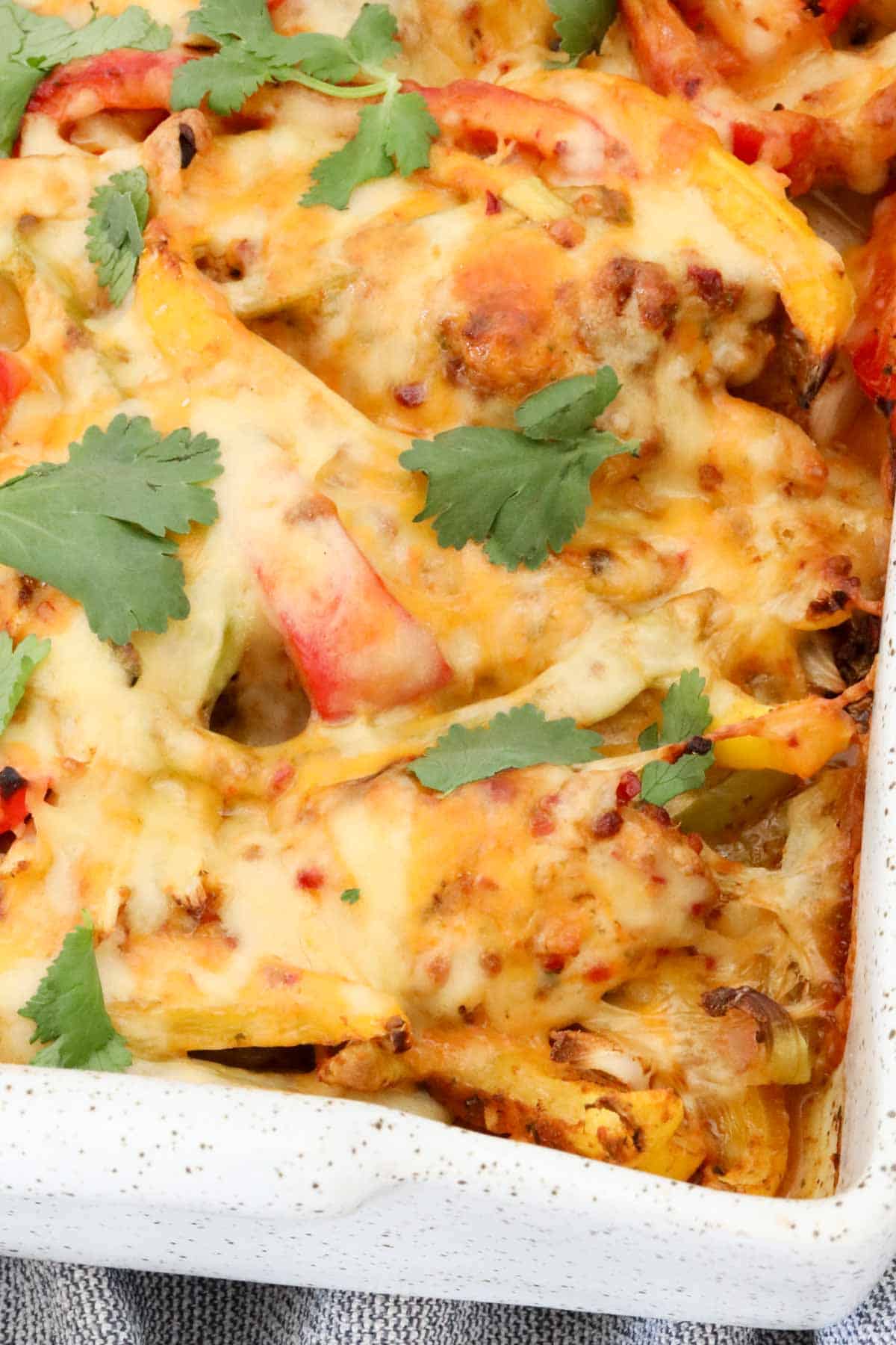 Close-up of cheesy chicken fajita casserole with colourful capsicum and melted cheese.