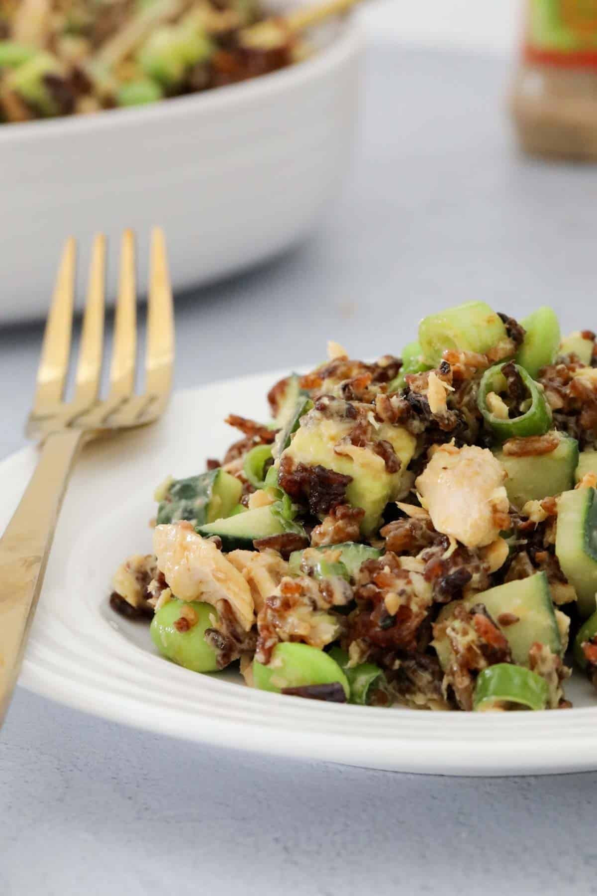 A plate of crispy rice salad with salmon and vegetables.