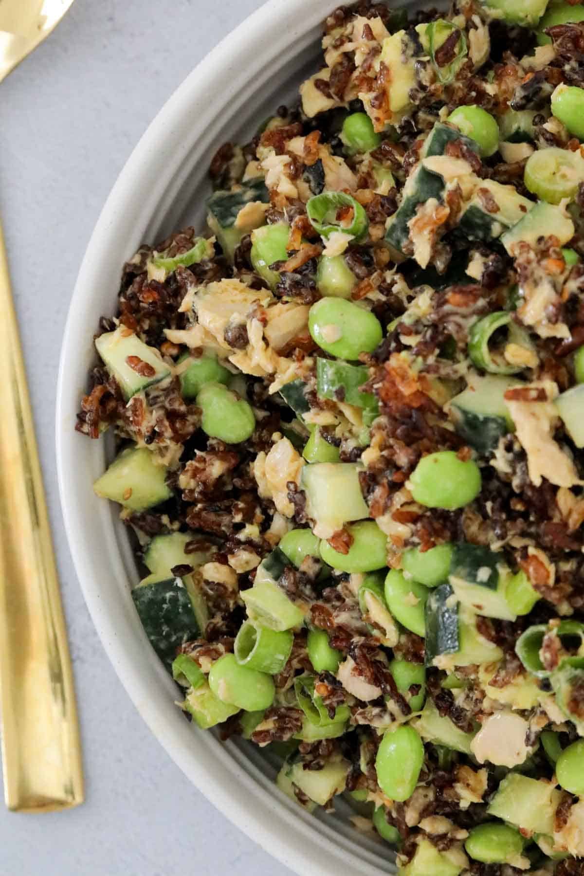 A bowl of crispy rice salad with edamame and avocado.