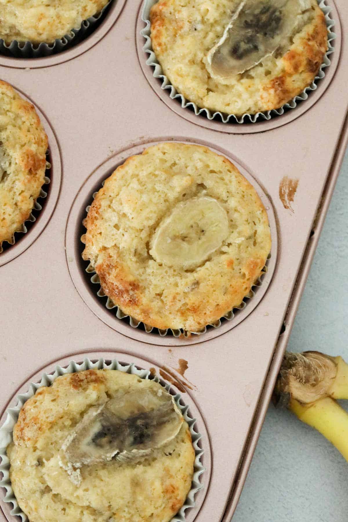 Greek banana yogurt muffins in a pink metal baking tray.