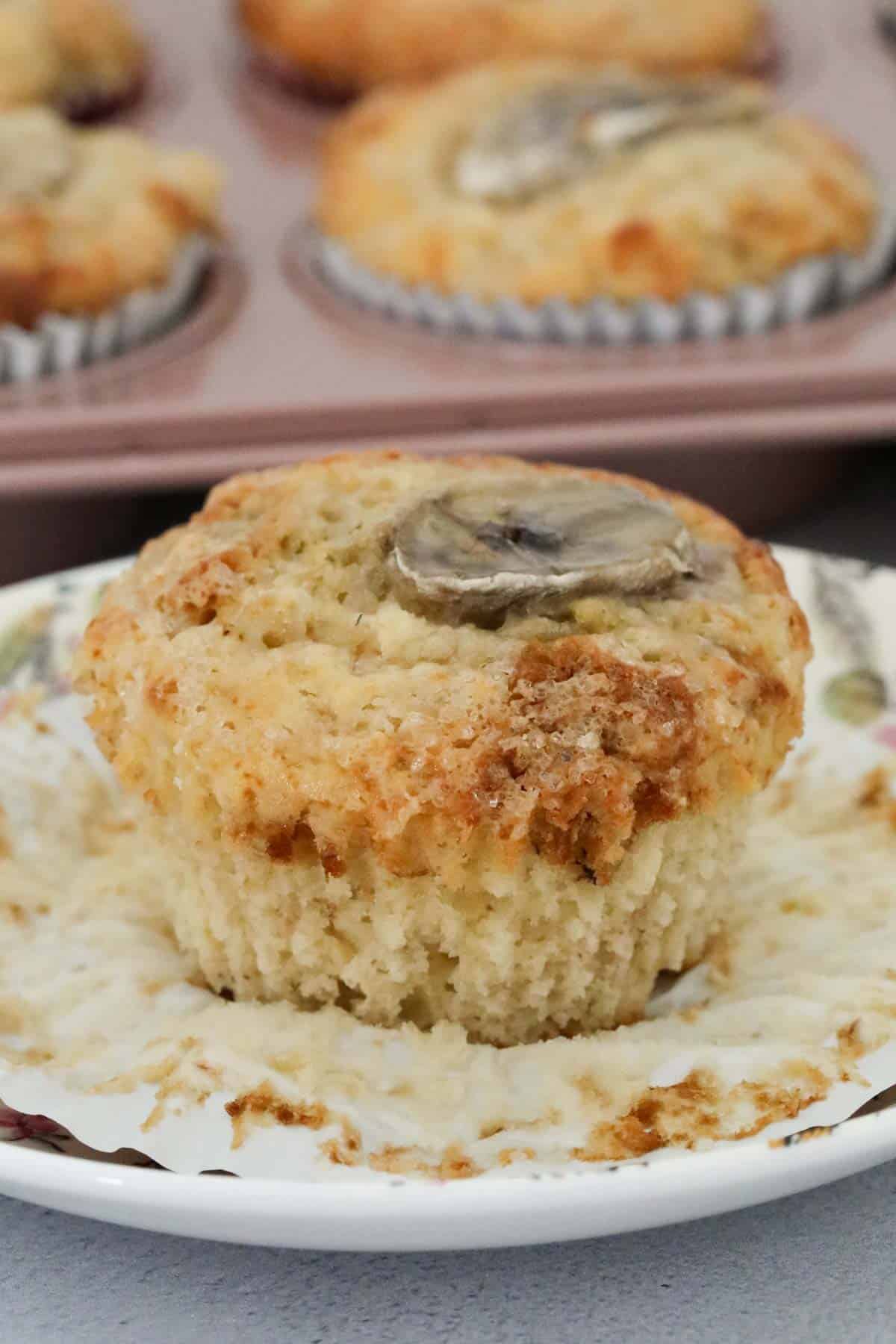 A greek yogurt muffin with a slice of banana baked on top.